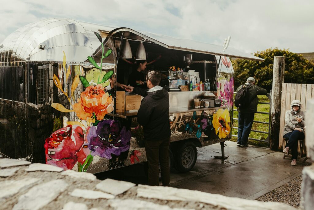 Food truck with colourful printed artwork serving customers
