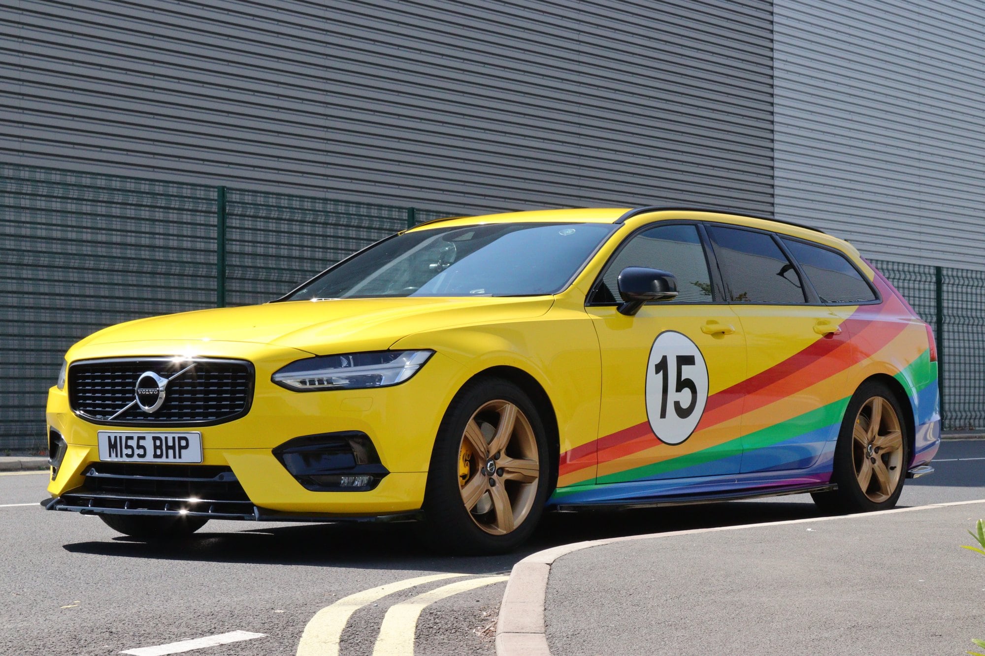 Volvo V90 in a gloss yellow full wrap with printed rainbow stripe graphics by Auto Wrap Manchester