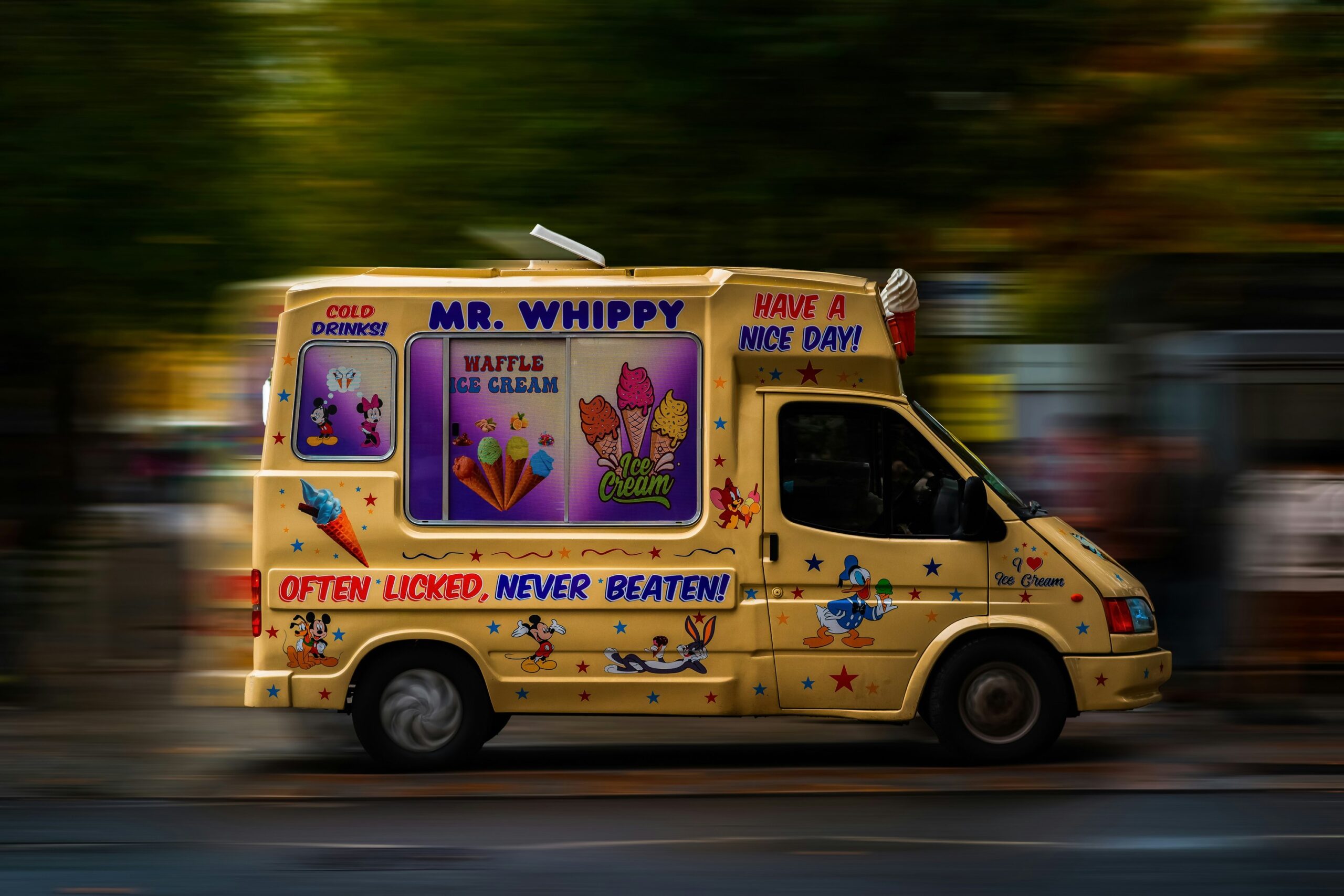 Ice cream van in a full printed wrap driving through a street